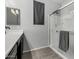 Bathroom features a glass enclosed shower with chrome hardware, tile floor, and window at 128 S 200Th Ave, Buckeye, AZ 85326