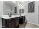 Stylish bathroom features dual sinks, a large mirror, modern faucets and neutral paint at 128 S 200Th Ave, Buckeye, AZ 85326