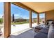 Covered patio offers ample space for seating, with a view of the backyard and blue skies above at 128 S 200Th Ave, Buckeye, AZ 85326