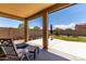 Inviting covered patio with a seating area overlooking the spacious backyard, perfect for outdoor relaxation at 128 S 200Th Ave, Buckeye, AZ 85326