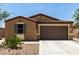 Single-story home boasts desert landscaping, a two-car garage, and attractive architectural details at 128 S 200Th Ave, Buckeye, AZ 85326