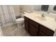 Cozy bathroom featuring a modern vanity with cabinets, a toilet, and a shower with white curtain at 13719 W Amberwing St, Peoria, AZ 85383