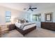 Bright bedroom features neutral tones, a ceiling fan, and large windows at 13719 W Amberwing St, Peoria, AZ 85383