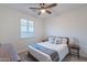 Comfortable bedroom featuring a ceiling fan, natural light, and side tables at 13719 W Amberwing St, Peoria, AZ 85383