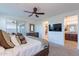 Comfortable bedroom with ceiling fan, dresser, and ensuite bath at 13719 W Amberwing St, Peoria, AZ 85383