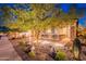 Lovely home exterior with manicured landscaping, a stone-accented facade, and a well-lit walkway leading to the front door at 13719 W Amberwing St, Peoria, AZ 85383