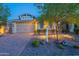 Beautiful single-Gathering home with a well-maintained lawn, stone accents, and inviting outdoor lighting at 13719 W Amberwing St, Peoria, AZ 85383