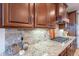 Kitchen features stainless steel appliances, granite countertops, and wooden cabinetry at 13719 W Amberwing St, Peoria, AZ 85383