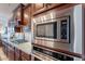 Close-up of stainless steel microwave, gas stovetop and backsplash at 13719 W Amberwing St, Peoria, AZ 85383