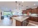 Open-concept kitchen with granite island and stainless appliances flowing into the living space at 13719 W Amberwing St, Peoria, AZ 85383