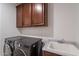 Functional laundry room features modern washer/dryer and built-in cabinets for added storage at 13719 W Amberwing St, Peoria, AZ 85383