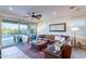 Spacious living room featuring a large sectional sofa and sliding glass doors with a view of the backyard pool at 13719 W Amberwing St, Peoria, AZ 85383