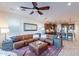 Spacious living room with a large leather sectional, ceiling fan, and an open view to the kitchen at 13719 W Amberwing St, Peoria, AZ 85383