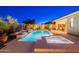 Luxurious backyard featuring a shimmering pool, a bubbling spa, and a cozy covered patio for outdoor enjoyment at 13719 W Amberwing St, Peoria, AZ 85383