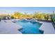 Gorgeous backyard pool with unique water features, surrounded by lush desert landscaping at 13719 W Amberwing St, Peoria, AZ 85383