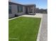 Wide shot of a backyard with green turf, gravel beds, and a covered patio at 1418 E Jacqueline Pl, Casa Grande, AZ 85122