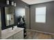 Modern bathroom featuring black accent wall with a white countertop sink and a large mirror at 1418 E Jacqueline Pl, Casa Grande, AZ 85122