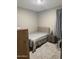 Modest bedroom with carpeted floor, a gray striped comforter, and a nightstand with a lamp, creating a cozy retreat at 1418 E Jacqueline Pl, Casa Grande, AZ 85122