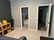 A clean bedroom featuring gray colored walls, and two doors, one leading to a closet with clothes hanging inside at 1418 E Jacqueline Pl, Casa Grande, AZ 85122