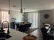 A dining room with a wooden table, black chairs, modern lighting, and a sliding glass door at 1418 E Jacqueline Pl, Casa Grande, AZ 85122