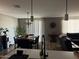 A dining room with a wooden table, black chairs, modern lighting, and a sliding glass door at 1418 E Jacqueline Pl, Casa Grande, AZ 85122