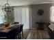 A dining room with a wooden table, black chairs, modern lighting, and a sliding glass door at 1418 E Jacqueline Pl, Casa Grande, AZ 85122