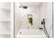 Luxurious bathroom with elegant, bright marble tiles, matte black fixtures, shelves, and a bathtub at 1425 E Diamond St, Phoenix, AZ 85006