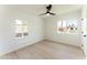 Bright bedroom with wood floors, modern ceiling fan, and a large window view at 1425 E Diamond St, Phoenix, AZ 85006