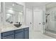 Stylish bathroom featuring a vessel sink, a walk-in shower with pebble flooring, and plenty of natural light at 14372 W Cypress St, Goodyear, AZ 85395
