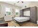 Neutral bedroom featuring a murphy bed, desk, and ample natural light from the window at 14372 W Cypress St, Goodyear, AZ 85395