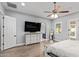 Bright primary bedroom with a ceiling fan, a large TV, and an ensuite bath with shutters at 14372 W Cypress St, Goodyear, AZ 85395