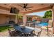 Covered patio featuring an outdoor dining area overlooking the pool and lush landscaping at 14372 W Cypress St, Goodyear, AZ 85395