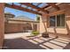 Covered outdoor patio features brick pavers, a swing, and a fire pit for entertaining at 14372 W Cypress St, Goodyear, AZ 85395