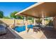 Inviting outdoor space featuring a sparkling pool, covered patio, and tranquil landscaping at 14372 W Cypress St, Goodyear, AZ 85395