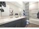 Modern bathroom with dual sinks, quartz countertop, and a large mirror over dark blue vanity at 14825 W Whitehorn Way, Surprise, AZ 85387