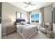 Comfortable bedroom featuring neutral decor, soft lighting, and a serene atmosphere with a large window at 14825 W Whitehorn Way, Surprise, AZ 85387