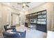 Bright home office featuring custom shelving, stylish desk, comfortable chairs, and a neutral color palette at 14825 W Whitehorn Way, Surprise, AZ 85387