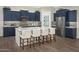 Modern kitchen with dark blue cabinets, stainless steel appliances, and a large center island with seating at 14825 W Whitehorn Way, Surprise, AZ 85387
