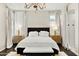 Elegant main bedroom boasts a black headboard, white bedding, accent lighting, and decorative chandelier at 14826 N 92Nd Pl, Scottsdale, AZ 85260