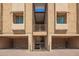 View of building exterior with garages and staircases leading to the units above at 151 E Broadway Rd # 103, Tempe, AZ 85282