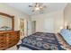 Carpeted bedroom with a ceiling fan, neutral paint and a dresser providing a bright and spacious feel at 16412 W Peppertree Ct, Surprise, AZ 85387