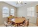 A dining room with a ceiling fan and an octagonally-shaped wooden dining table at 16412 W Peppertree Ct, Surprise, AZ 85387