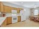 Bright kitchen with oak cabinets, white countertops, and appliances, plus an adjacent dining area with a ceiling fan at 16412 W Peppertree Ct, Surprise, AZ 85387