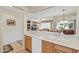Cozy kitchen featuring light countertops and wooden cabinets with a view into the living area at 16412 W Peppertree Ct, Surprise, AZ 85387