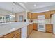 Well-lit kitchen with oak cabinets, white appliances, and a breakfast bar overlooking the dining area at 16412 W Peppertree Ct, Surprise, AZ 85387