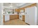 Well-lit kitchen with white appliances, light countertops, and wooden cabinets at 16412 W Peppertree Ct, Surprise, AZ 85387
