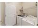 Well-lit laundry room features a modern washer, dryer and convenient overhead shelving at 16412 W Peppertree Ct, Surprise, AZ 85387