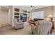 Inviting living room features built-in shelves, a ceiling fan, and comfortable seating arrangement at 16412 W Peppertree Ct, Surprise, AZ 85387