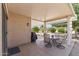 Comfortable covered patio area with an outdoor dining set and grill, perfect for entertaining at 16412 W Peppertree Ct, Surprise, AZ 85387