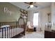 Bedroom featuring a crib, comfortable armchair, and soft, decorative elements at 17032 N 16Th Dr # 8, Phoenix, AZ 85023